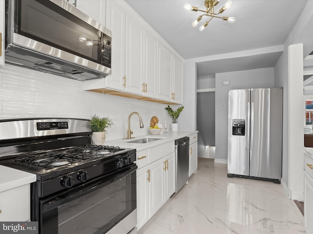 kitchen featuring marble finish floor, white cabinetry, stainless steel appliances, and a sink