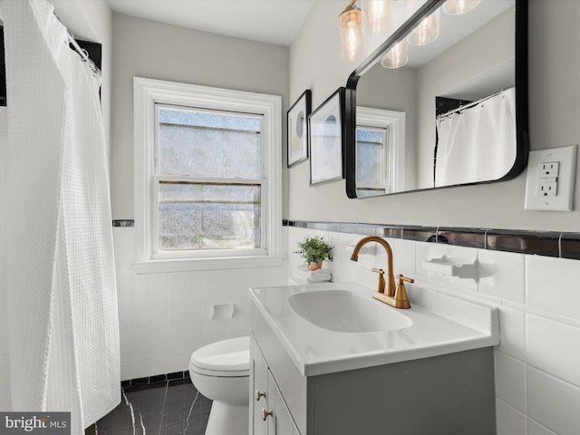 full bathroom with wainscoting, toilet, tile walls, and vanity