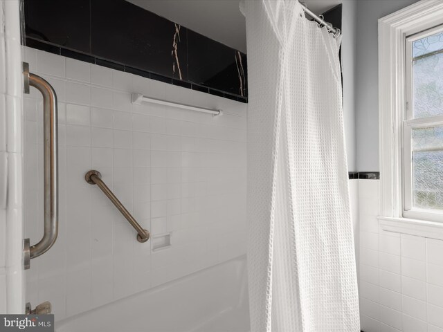 bathroom featuring a shower with shower curtain and a wealth of natural light