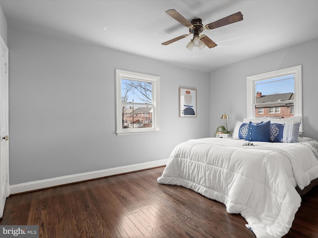 bedroom featuring a ceiling fan, baseboards, and wood finished floors