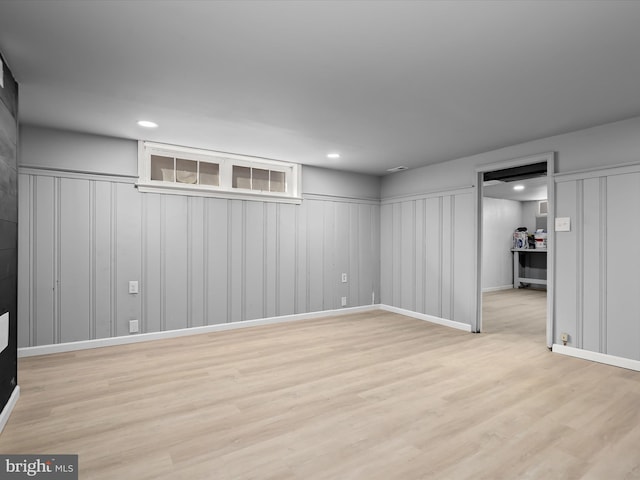 finished below grade area with light wood-style flooring and recessed lighting