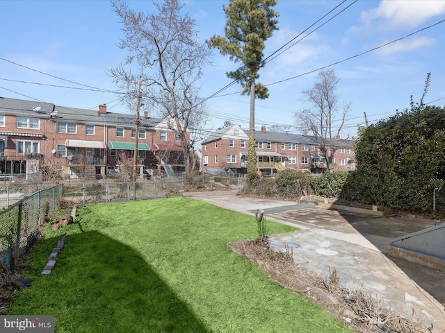 view of yard featuring a patio area, a residential view, and fence