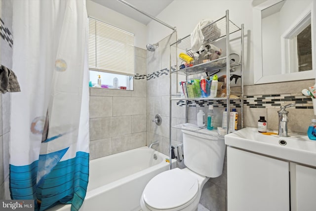 bathroom with tasteful backsplash, toilet, shower / bath combination with curtain, vanity, and tile walls