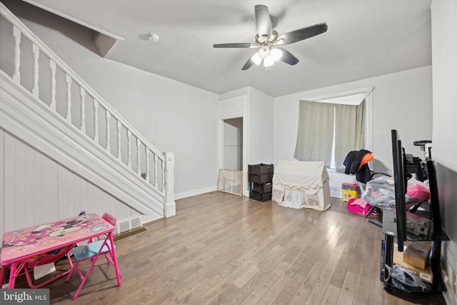 interior space with ceiling fan, wood finished floors, and baseboards