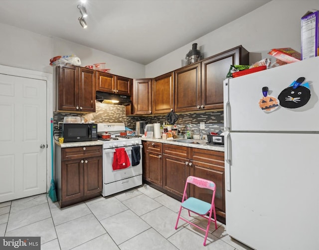 kitchen featuring light countertops, decorative backsplash, a sink, white appliances, and under cabinet range hood