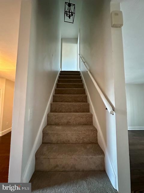 stairs with baseboards and wood finished floors