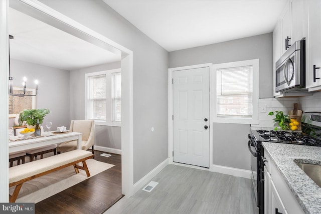 dining area featuring visible vents, light wood-style floors, a wealth of natural light, and baseboards