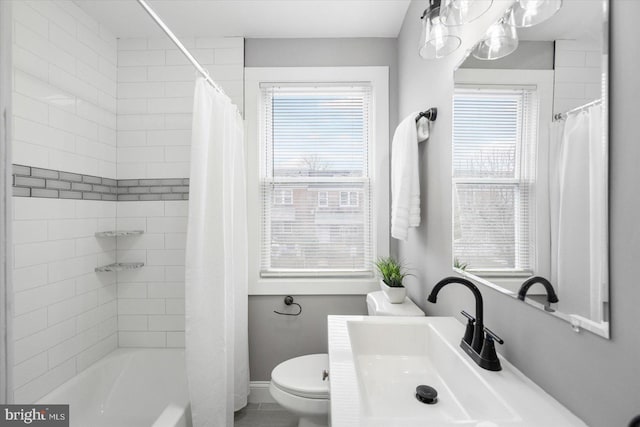 bathroom featuring a wealth of natural light, baseboards, shower / tub combo with curtain, and toilet