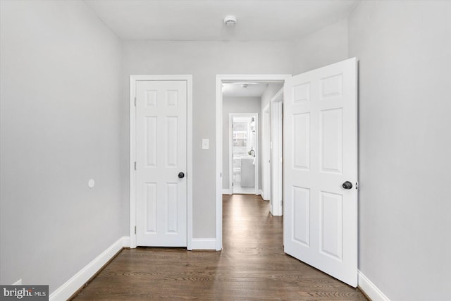 hallway with baseboards and dark wood-style flooring