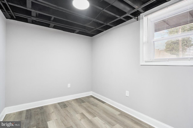 basement featuring baseboards and wood finished floors