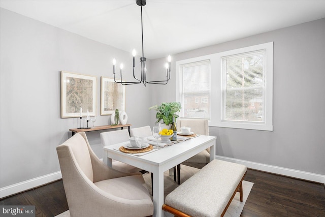 dining area with a notable chandelier, baseboards, and wood finished floors