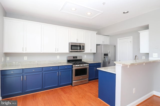 kitchen with blue cabinets, light wood-type flooring, appliances with stainless steel finishes, and white cabinets