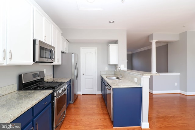 kitchen with blue cabinetry, stainless steel appliances, light wood-style floors, white cabinets, and a sink