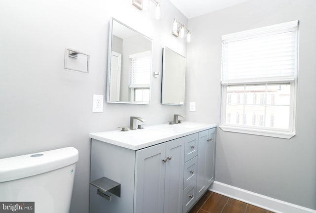 bathroom with a wealth of natural light, baseboards, and a sink