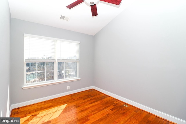 unfurnished room with ceiling fan, wood finished floors, visible vents, and baseboards