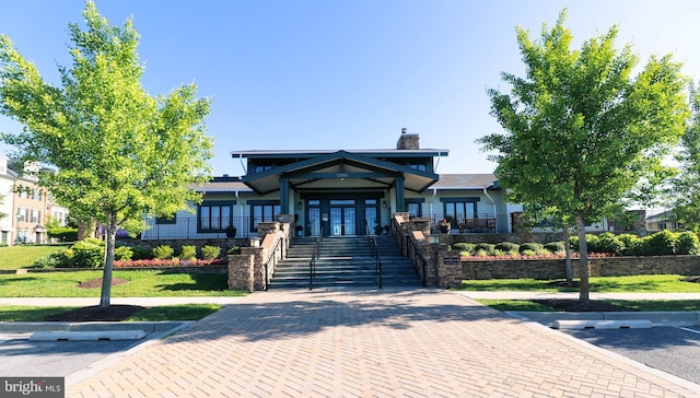 view of front of home featuring a front yard, french doors, and a chimney