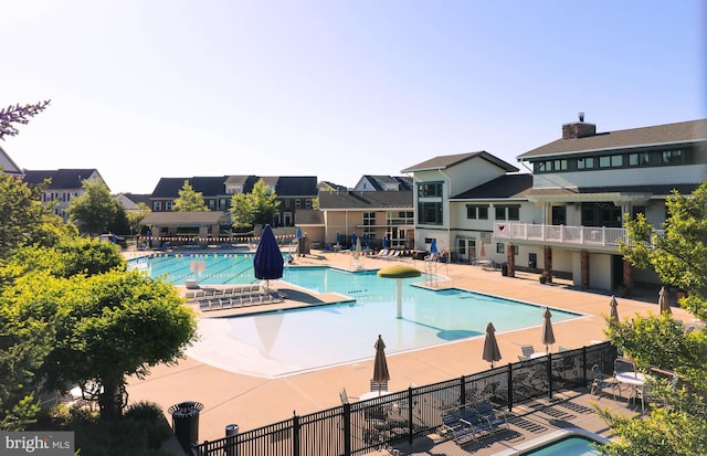 community pool featuring fence and a patio