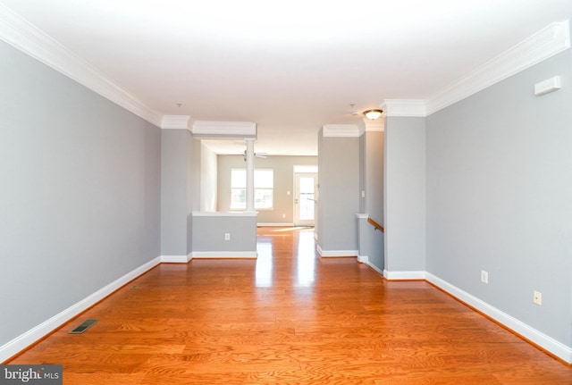 unfurnished room with baseboards, crown molding, visible vents, and light wood finished floors