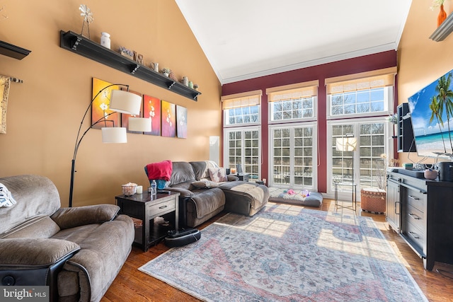 living room featuring vaulted ceiling, crown molding, and wood finished floors