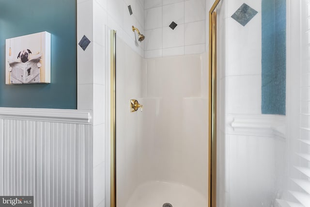 full bath featuring a stall shower and wainscoting