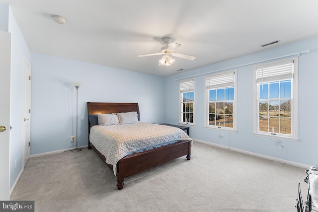 carpeted bedroom with visible vents, multiple windows, and baseboards