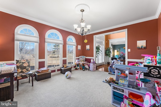 rec room with a notable chandelier, carpet flooring, crown molding, and a wainscoted wall