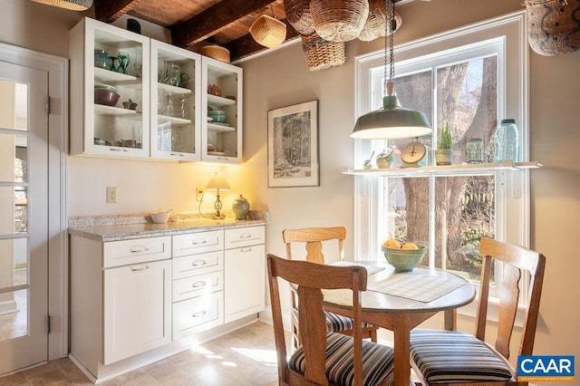 dining area featuring beam ceiling