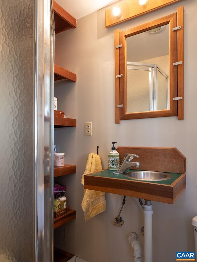 full bath featuring a stall shower, toilet, and a sink