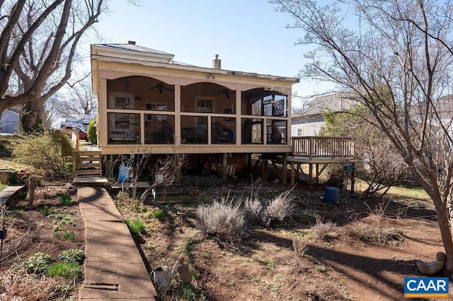 back of house featuring stairway, a ceiling fan, a deck, and a sunroom