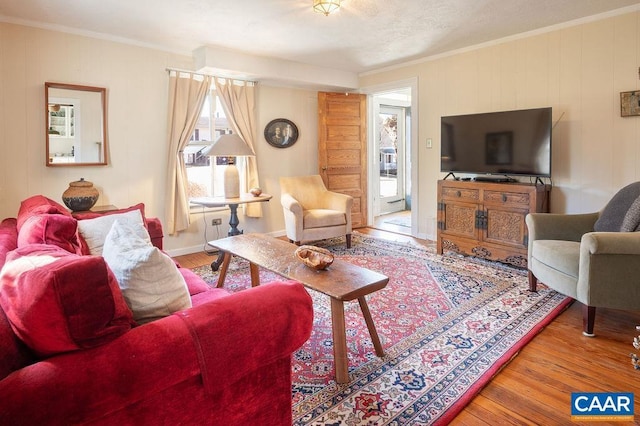 living area with crown molding and wood finished floors