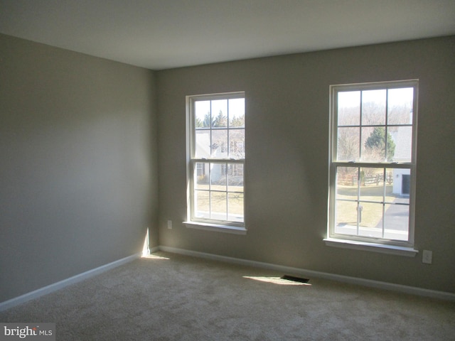 carpeted empty room featuring baseboards