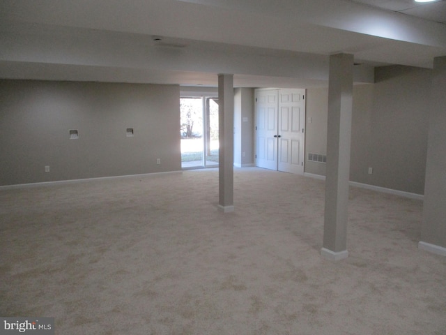 below grade area with carpet flooring, visible vents, and baseboards