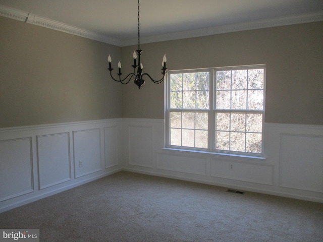 empty room with light carpet, a wainscoted wall, and a decorative wall