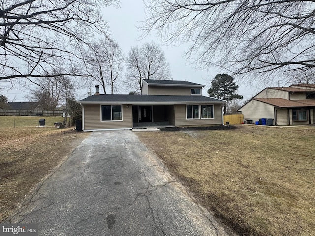 view of front of property with a front yard, driveway, and fence