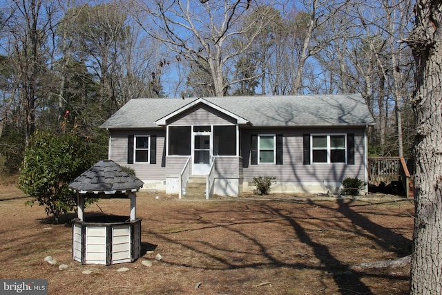 view of front facade featuring roof with shingles and a sunroom