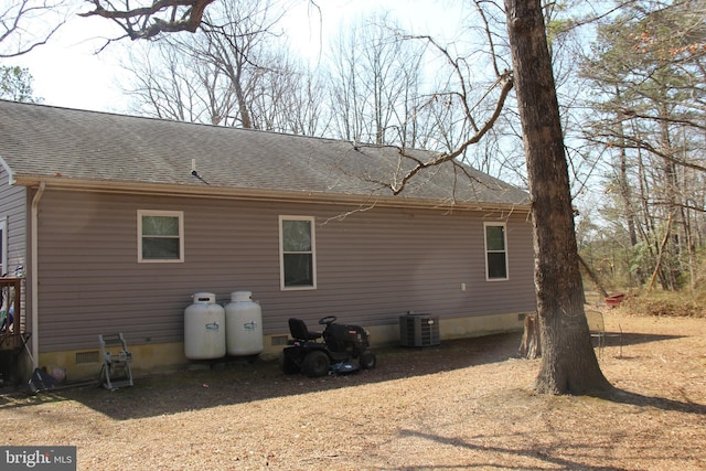 rear view of house with crawl space, roof with shingles, and central AC unit