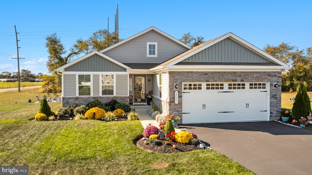 craftsman-style home with an attached garage, board and batten siding, a front yard, stone siding, and driveway