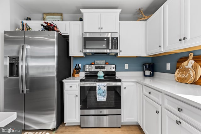 kitchen featuring white cabinets, stainless steel appliances, and light countertops