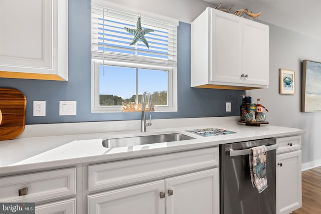 kitchen featuring wood finished floors, a sink, white cabinetry, light countertops, and stainless steel dishwasher