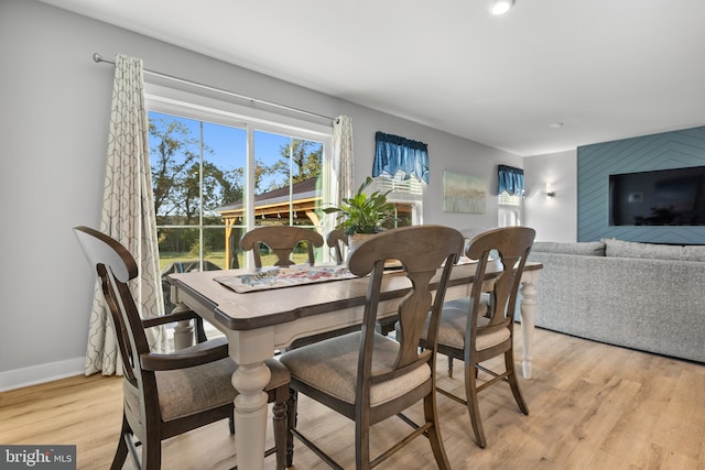 dining space with light wood-type flooring and baseboards