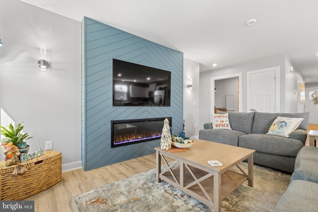 living area featuring recessed lighting, a fireplace, baseboards, and wood finished floors