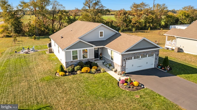 view of front of house with a garage, stone siding, driveway, and a front lawn