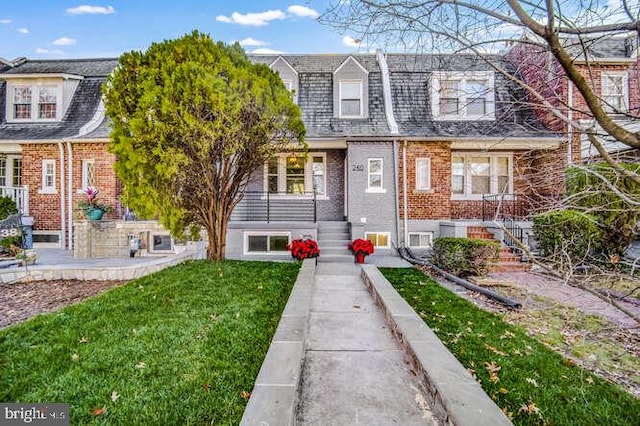 multi unit property featuring brick siding and a front lawn