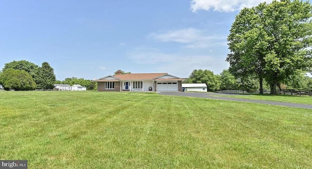 single story home featuring aphalt driveway, a garage, and a front lawn