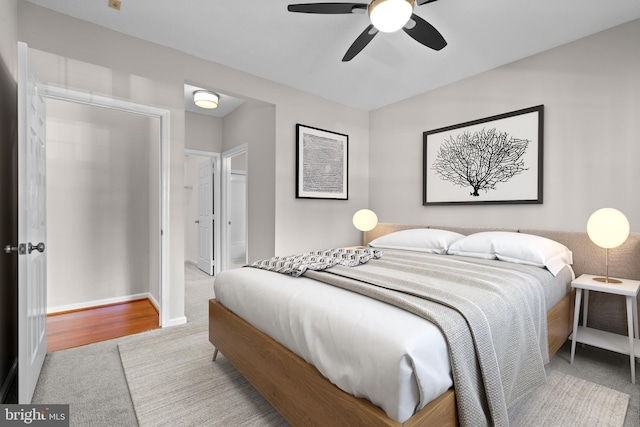 carpeted bedroom with ceiling fan and baseboards