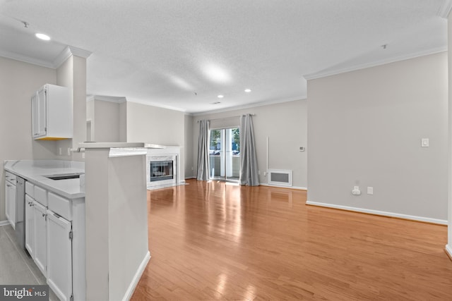 unfurnished living room with light wood-style floors, crown molding, baseboards, and a premium fireplace