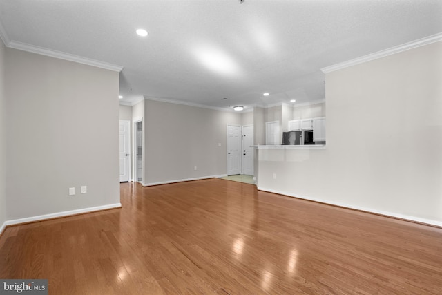 unfurnished living room with ornamental molding, recessed lighting, light wood-style flooring, and baseboards