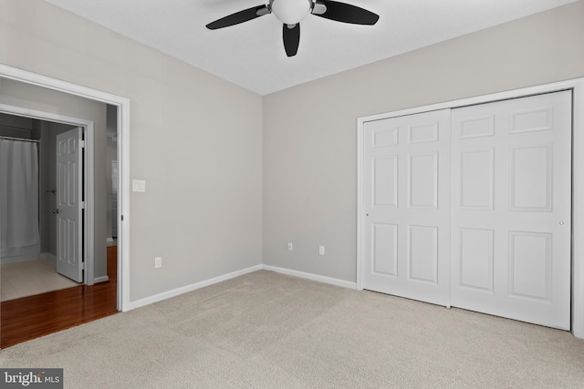 unfurnished bedroom with ceiling fan, a closet, baseboards, and carpet flooring