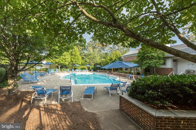 community pool with a patio area and fence