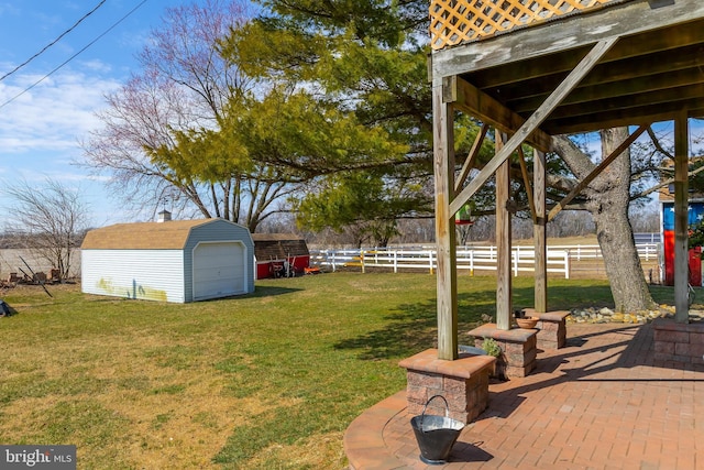 view of yard with fence, an outbuilding, a patio, and a shed